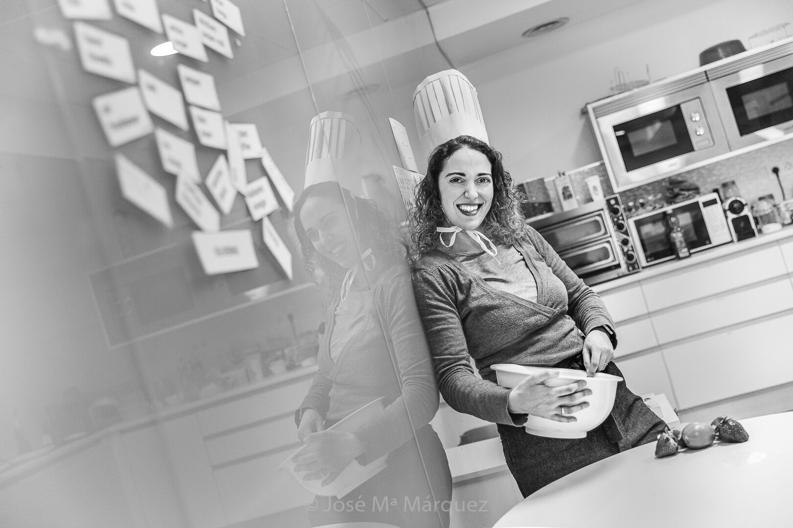 Retrato corporativo informal parte de un reportaje corporativo para la empresa Novatec en Granada, chicas con gorro de chef batiendo en la cocina de la empresa Chica con gorro de chef cocinando en la cocina de la empresa Novatec en Granada, reportaje corporativo realizado por José María Márquez fotógrafo de empresas