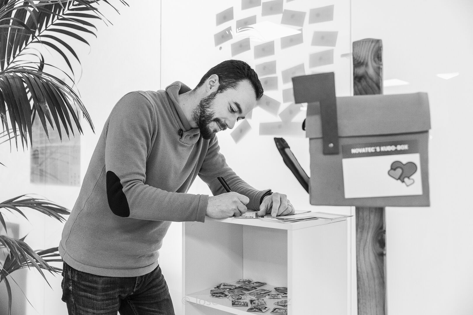 Fotografía de reportaje corporativo para la empresa Novatec en Granada, chico escribiendo una nota para el buzón de sugerencias de de la empresa Chico escribiendo una nota para el buzón de sugerencias de de la empresa Novatec en Granada, reportaje corporativo realizado por José María Márquez fotógrafo de empresas