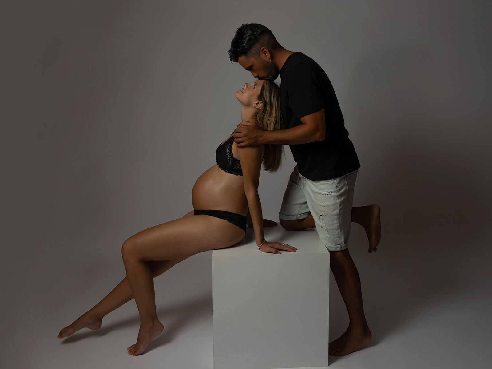 Retrato íntimo y tierno de pareja durante sesión de embarazo en estudio profesional en Cartagena por Torres & Torres Fotografía 