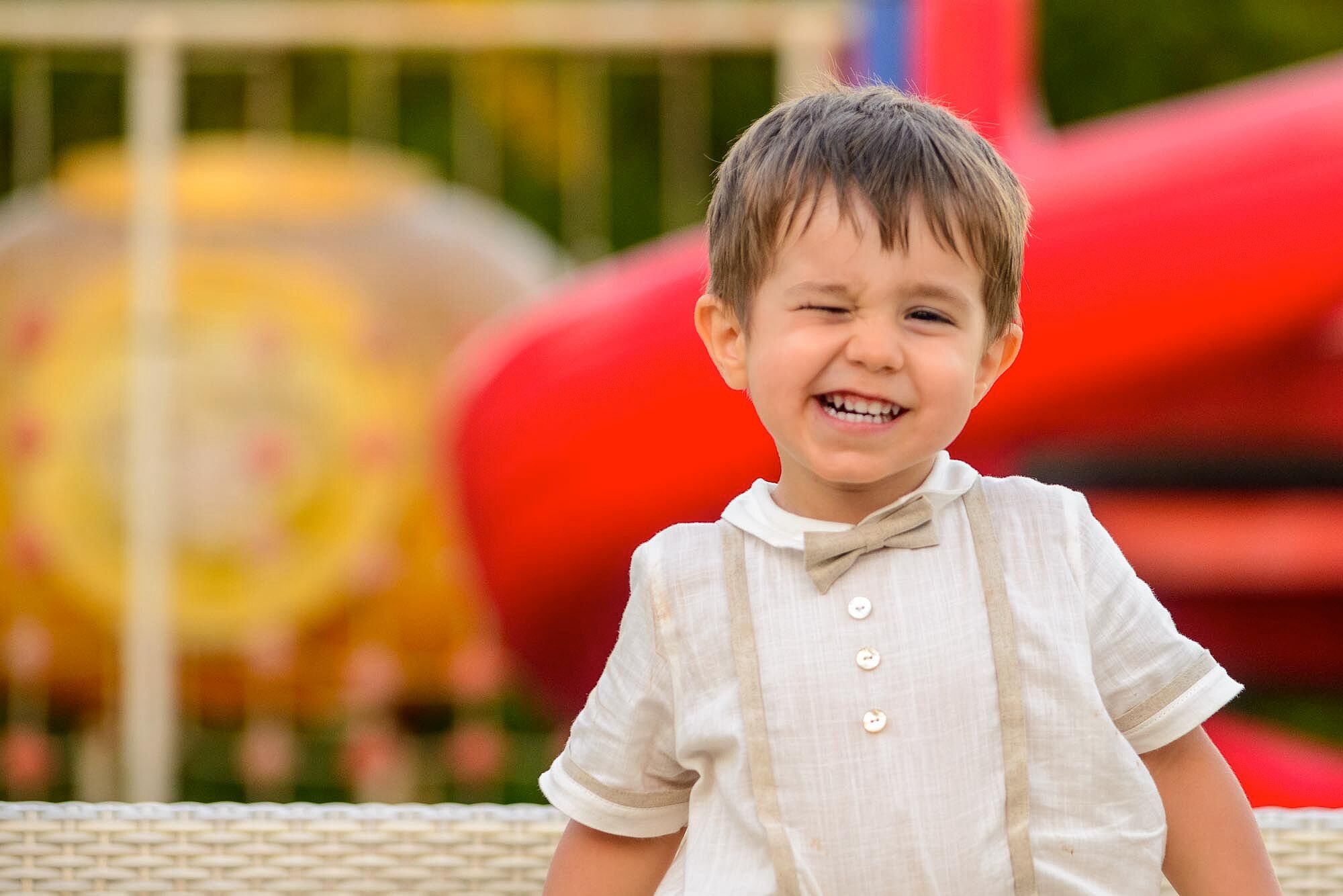 menino no dia do batismo a picar o olho