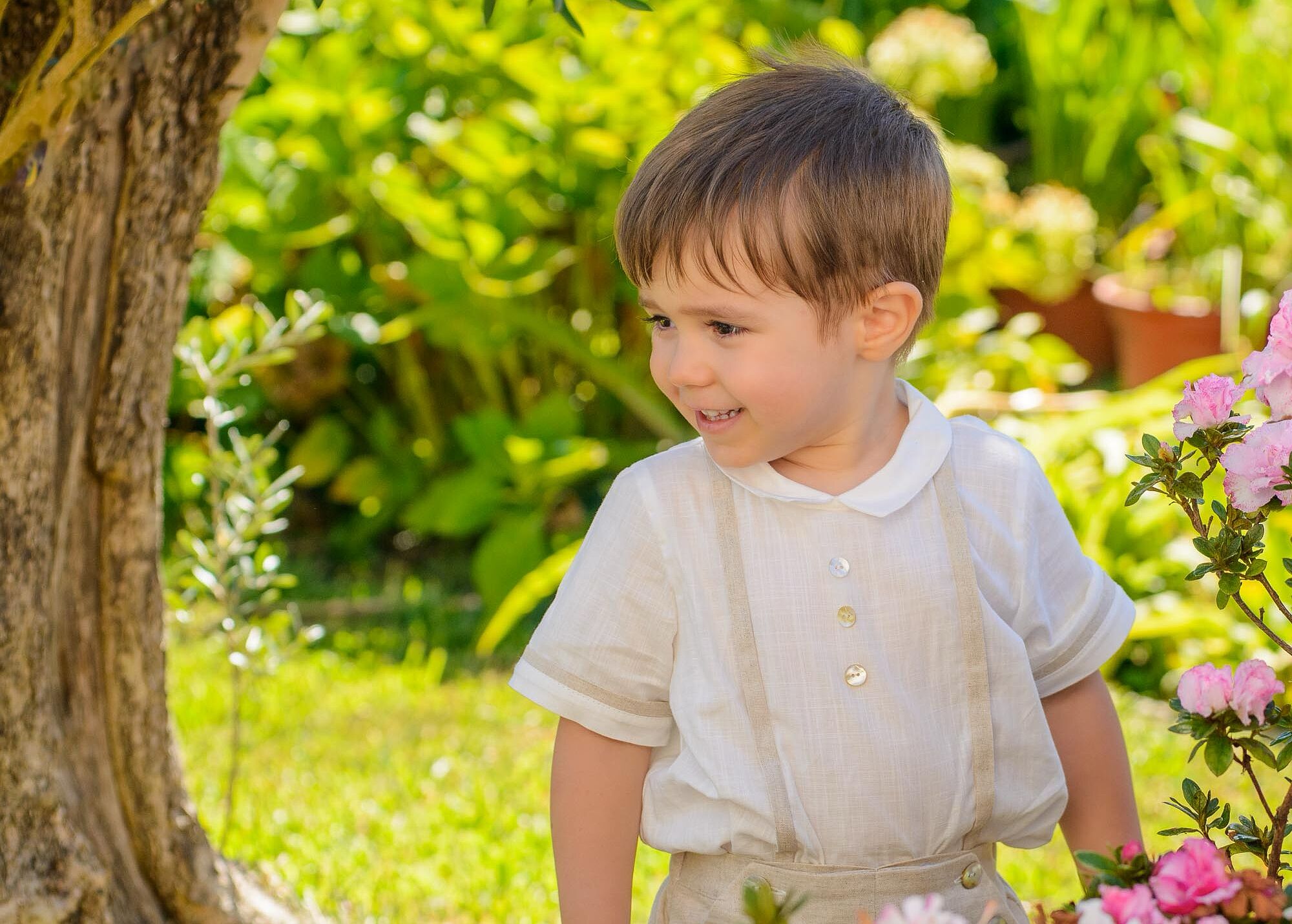 menino junto a flores no jardim de sua casa