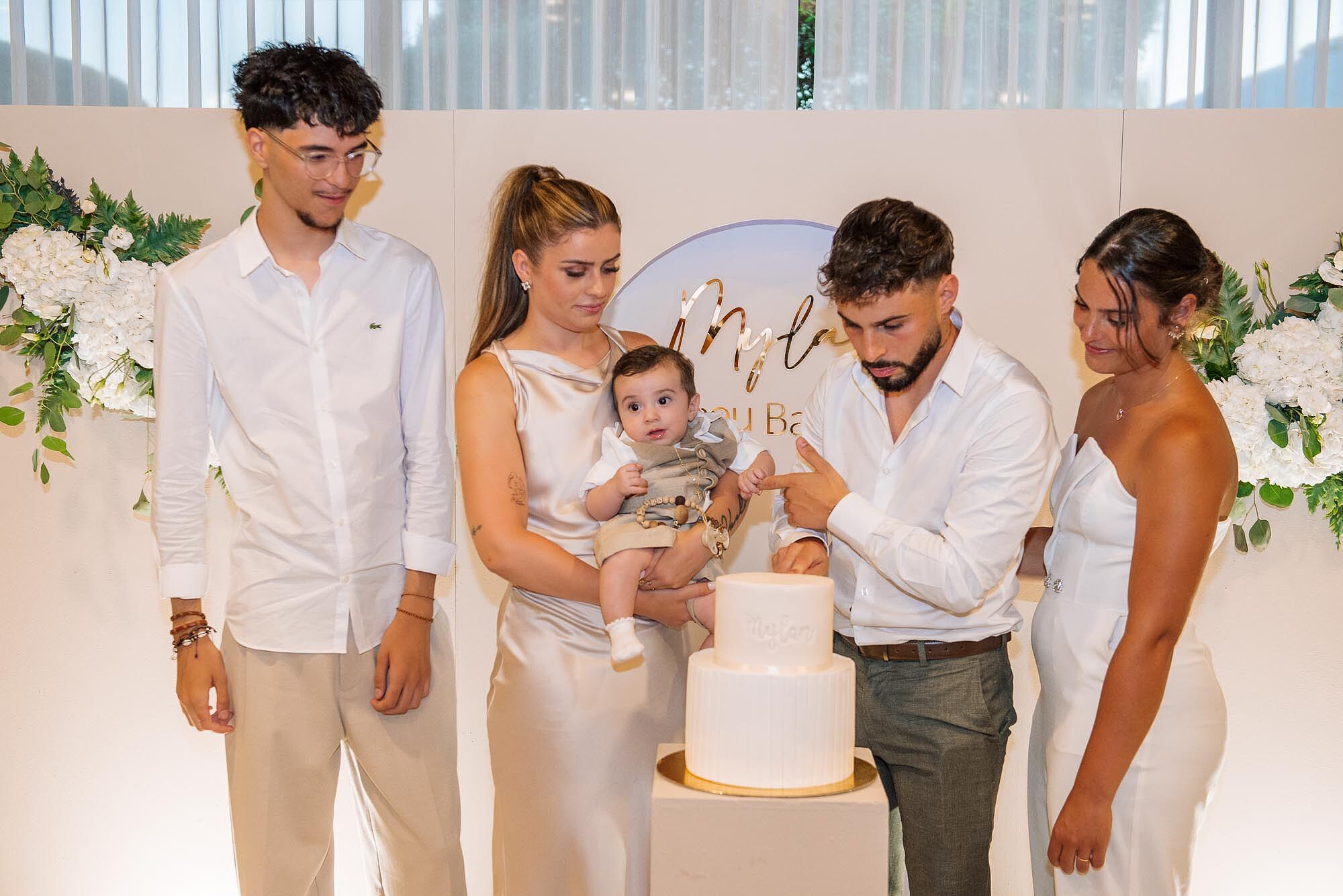 pais e padrinhos no corte de bolo de batismo