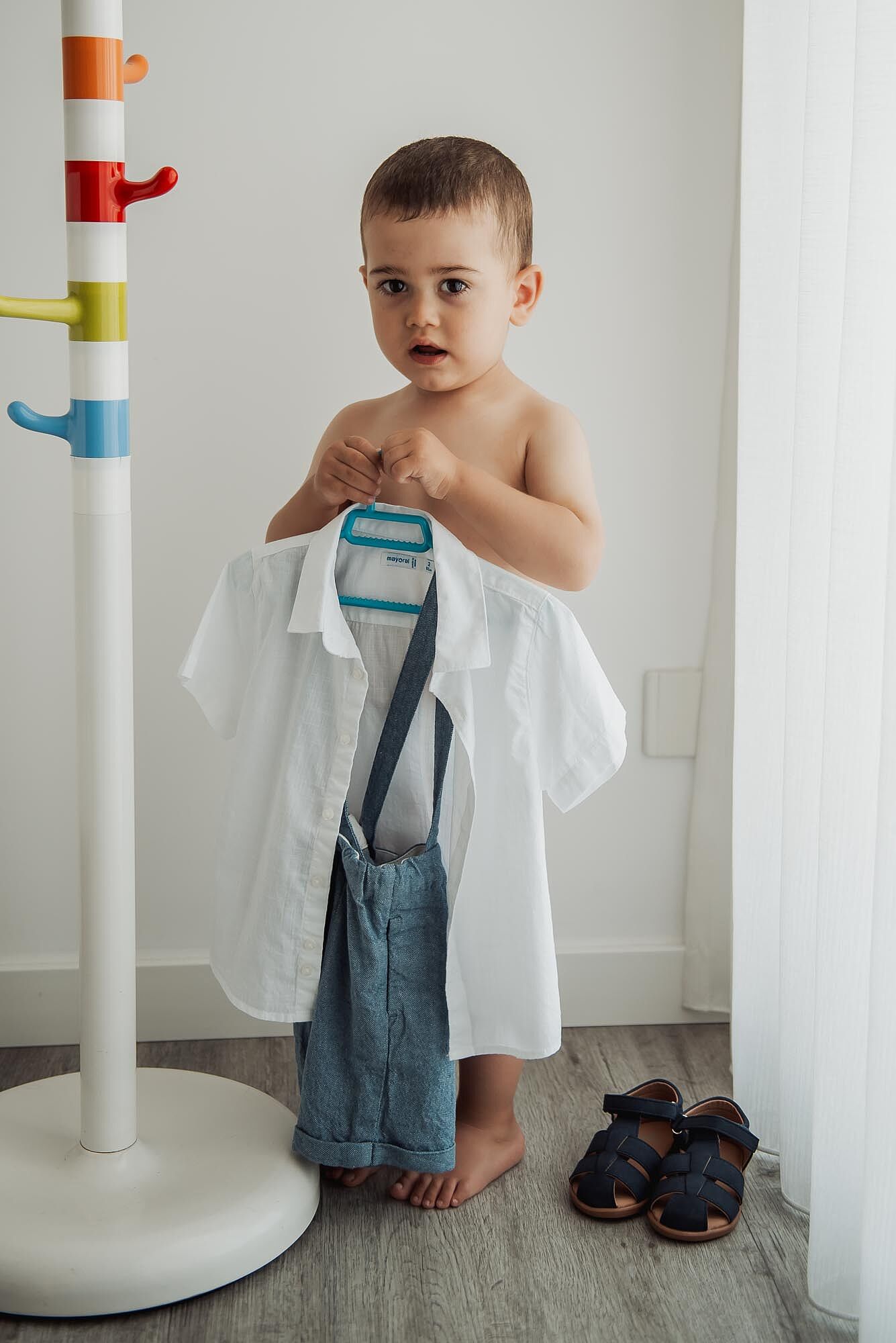 criança a segurar a sua roupa no dia do batismo