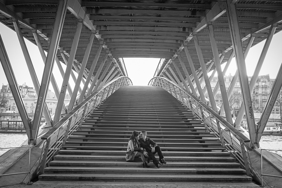 Casal de namorados sentados nas escadas da ponte