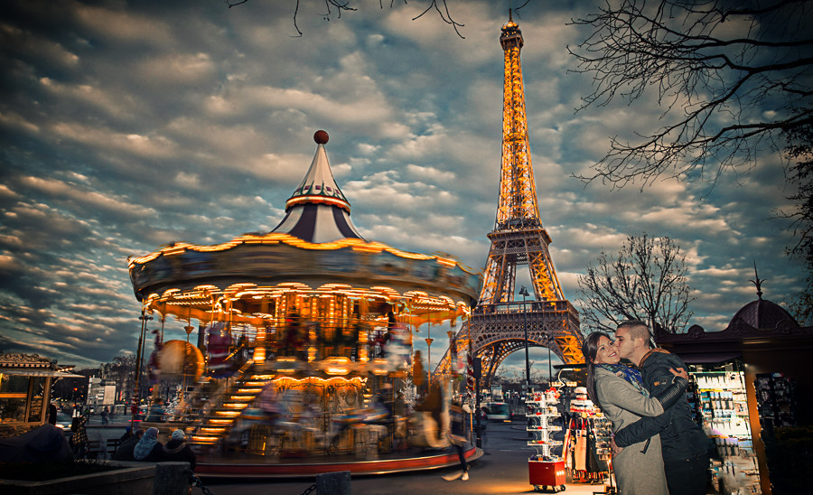Casal de namorados abraçados num parque de diversões