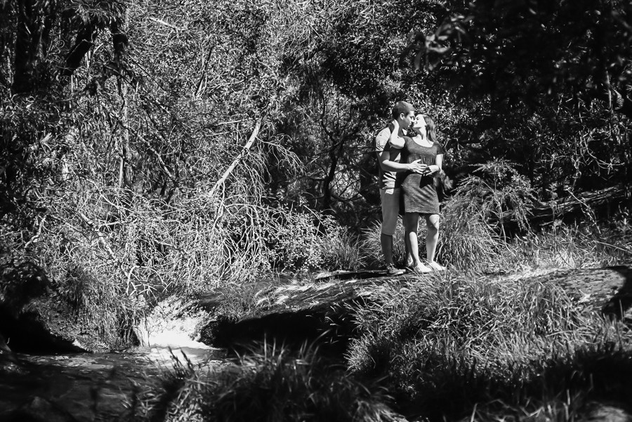 Homem a abraçar por trás a sua namorada e a a beijarem-se 