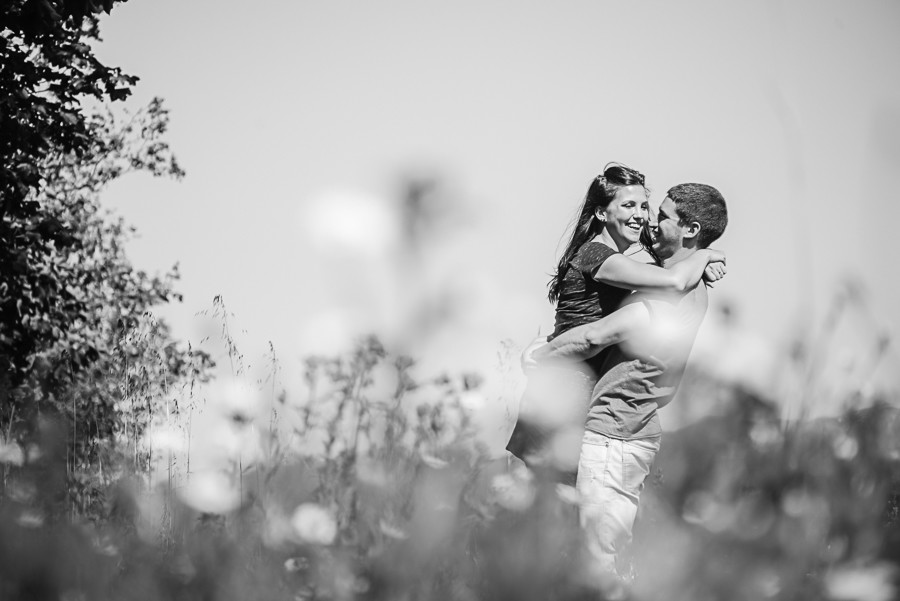 Homem a pegar na namorada ao colo e a sorrirem