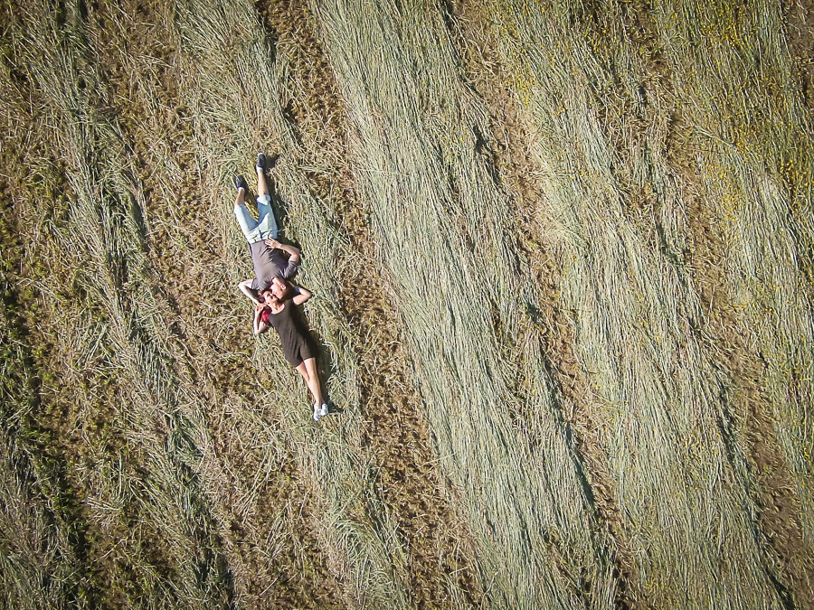 Casal de namorados deitados no campo cara a cara