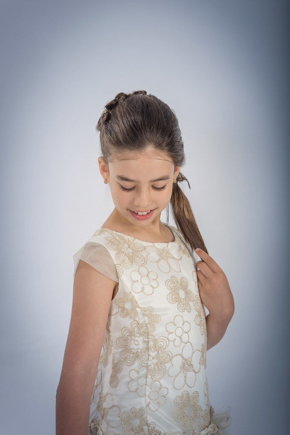 Menina de vestido a olhar para baixo enquanto faz carinho no próprio cabelo