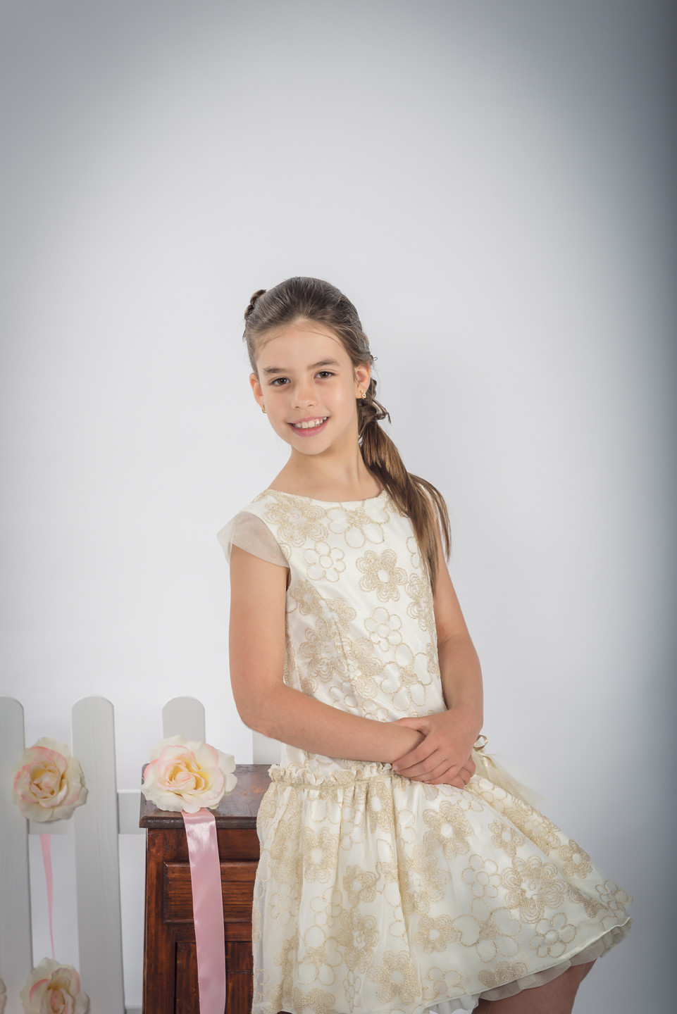 Menina de vestido sentada e a sorrir