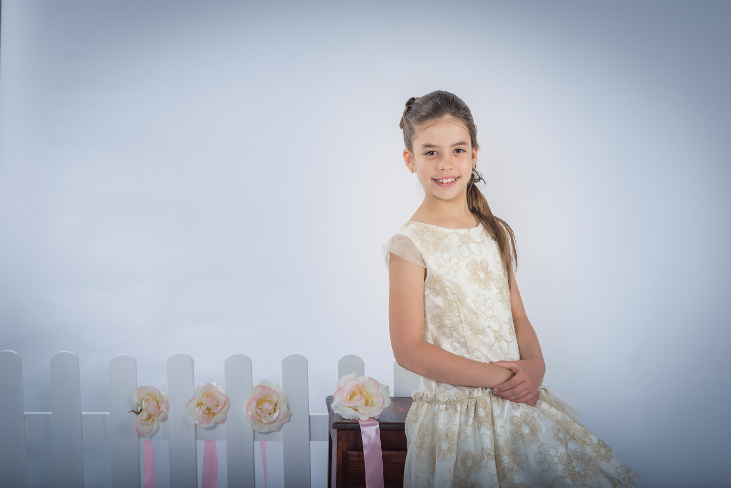 Menina de vestida de mãos cruzadas e a sorrir
