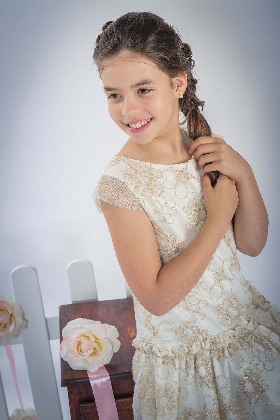 Menina de vestido a sorrir enquanto mexe no cabelo
