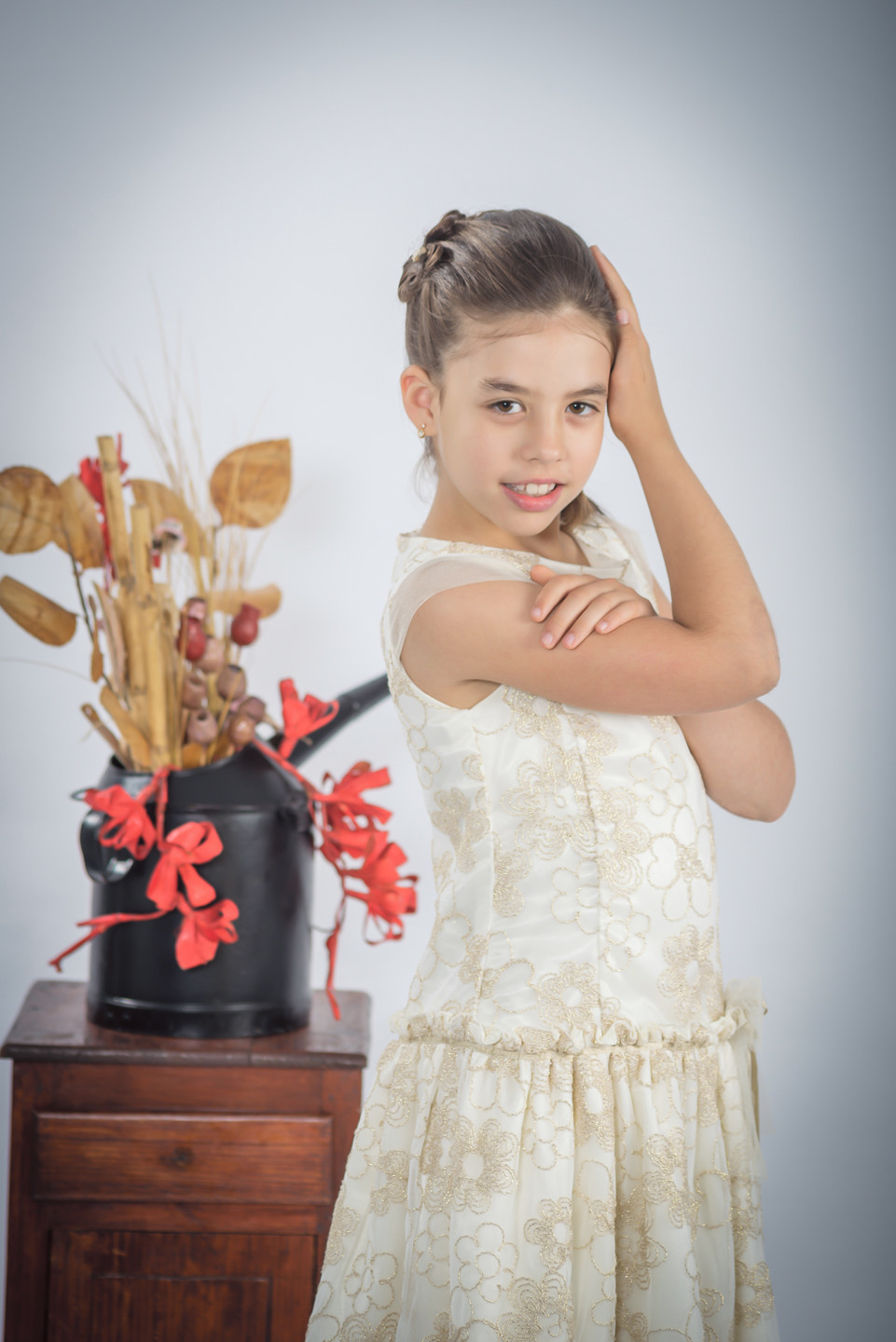 Menina de vestido com a mão na cabeça e outra apoiada no braço