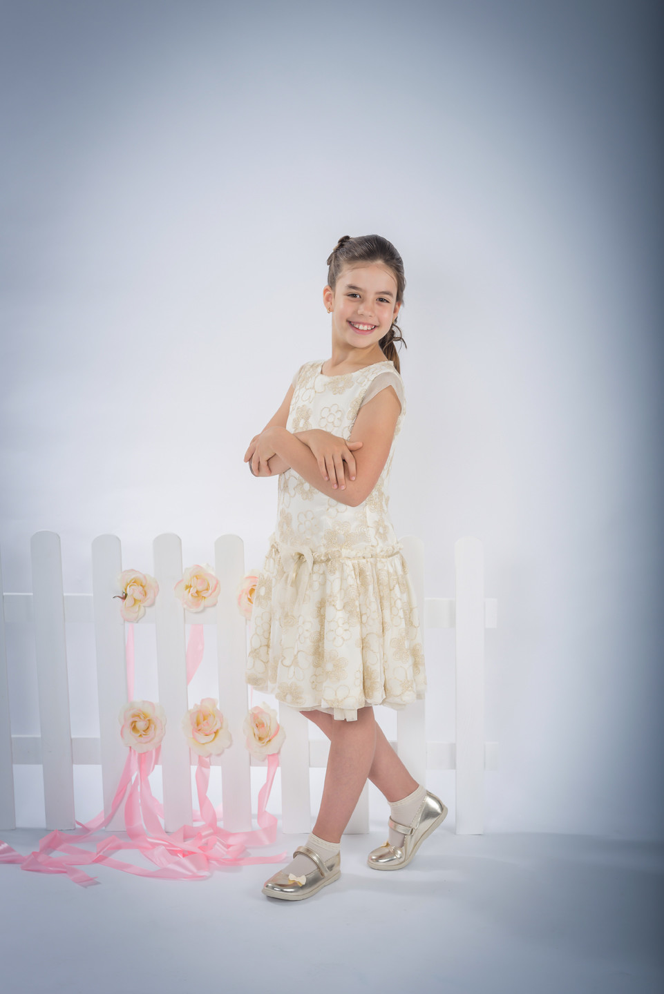 Menina de vestido a sorrir de braços cruzados