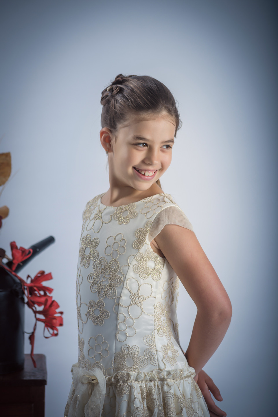 Menina de vestido a sorrir com as mãos atrás das costas