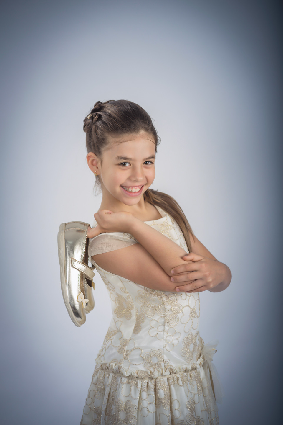 Menina de vestido a segurar os sapatos