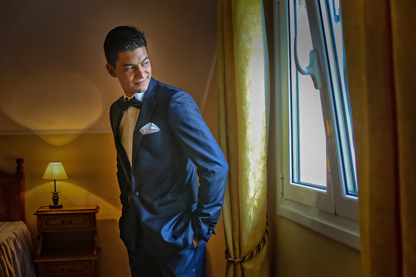 Noivo de fato azul a olhar para a janela