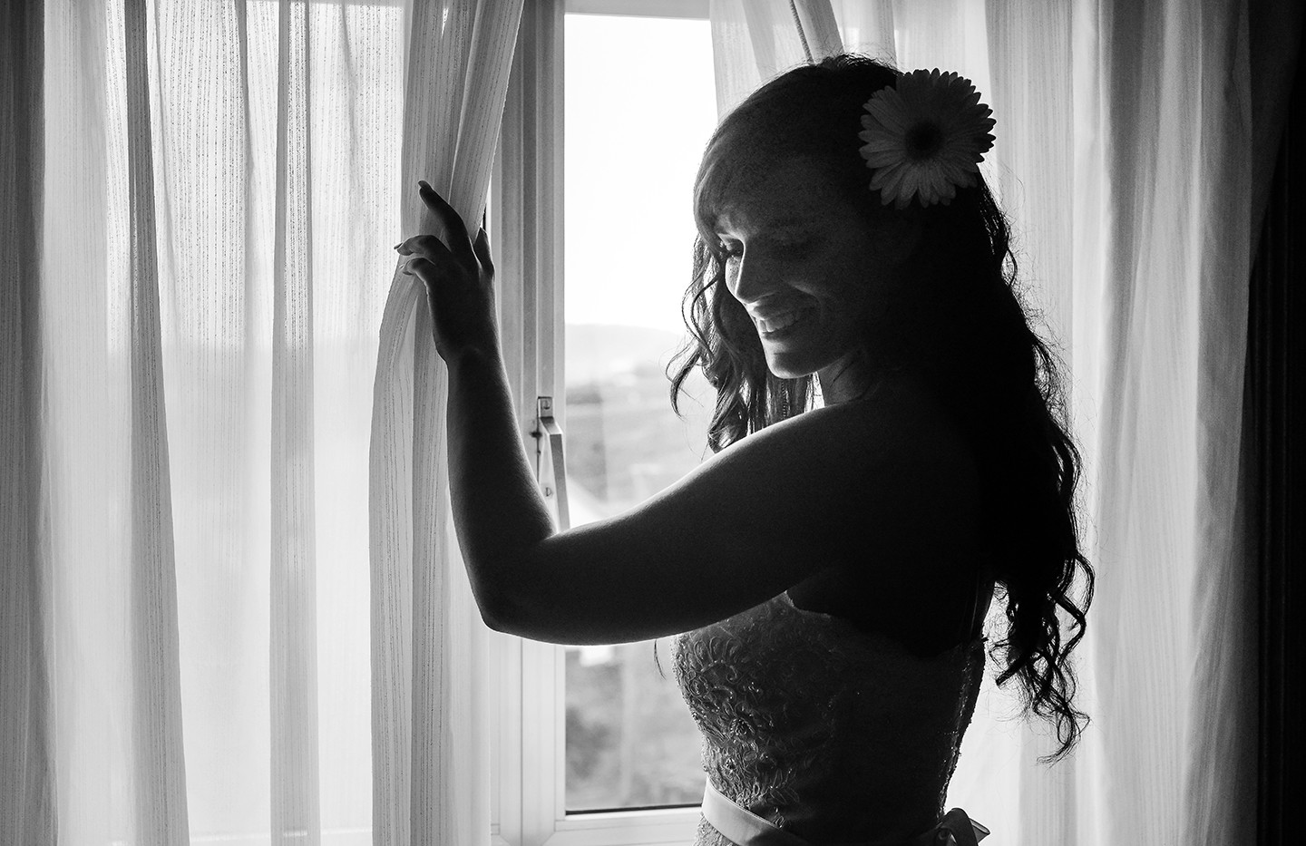 Noiva a afastar a cortina da janela