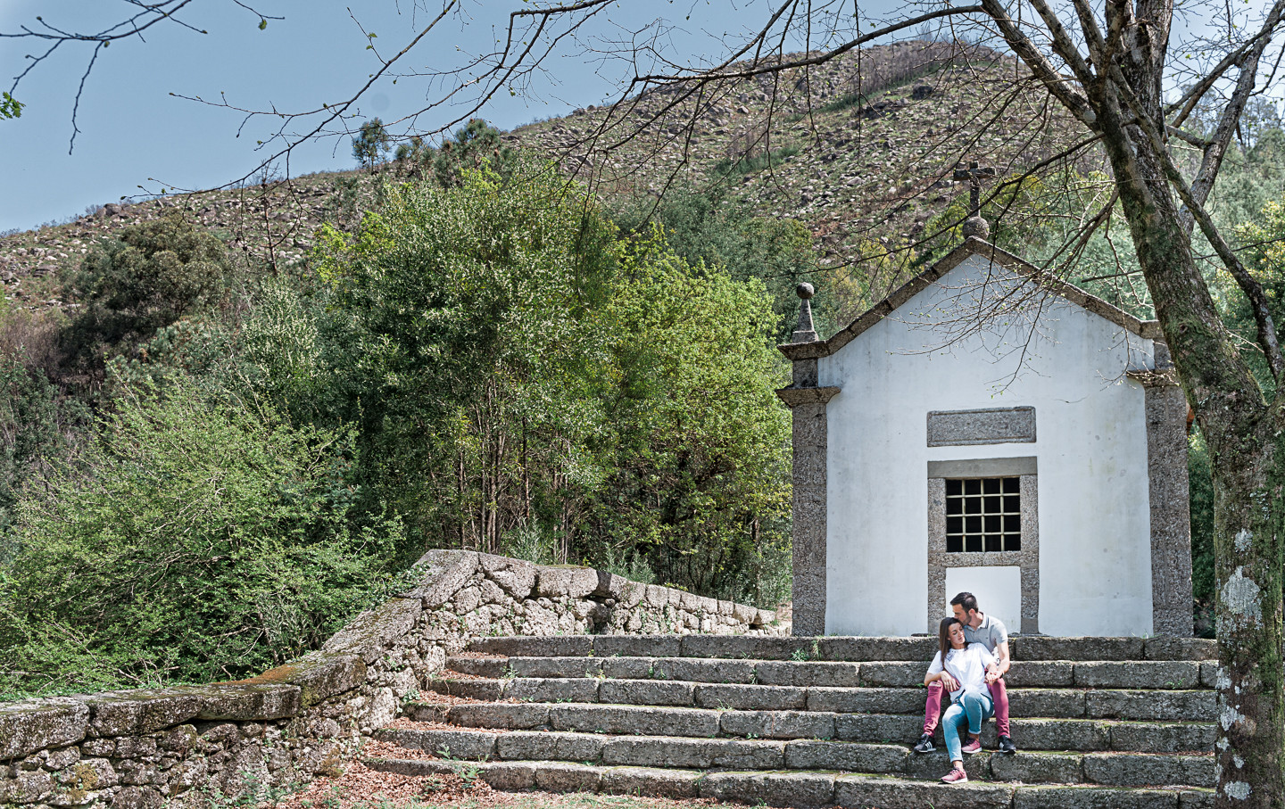 Cidália e Jorge sentados nas escadas enquanto ele da-lhe um beijo na bochecha