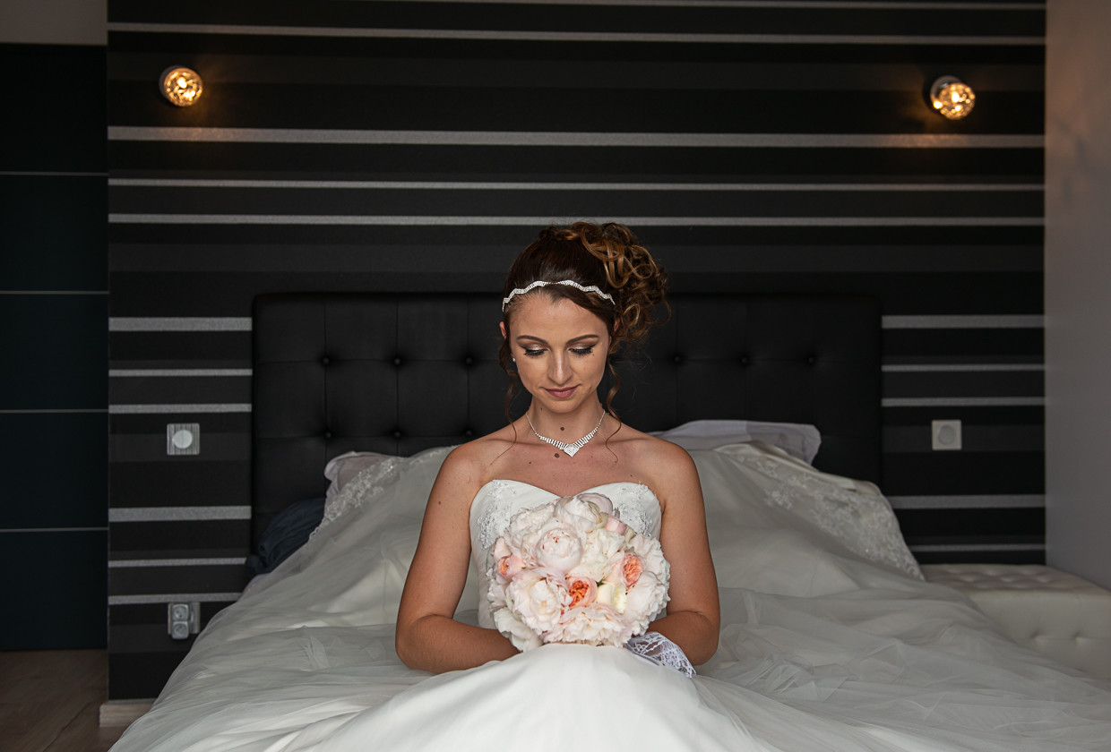 Charlène sentada com a olhar para o buque de flores