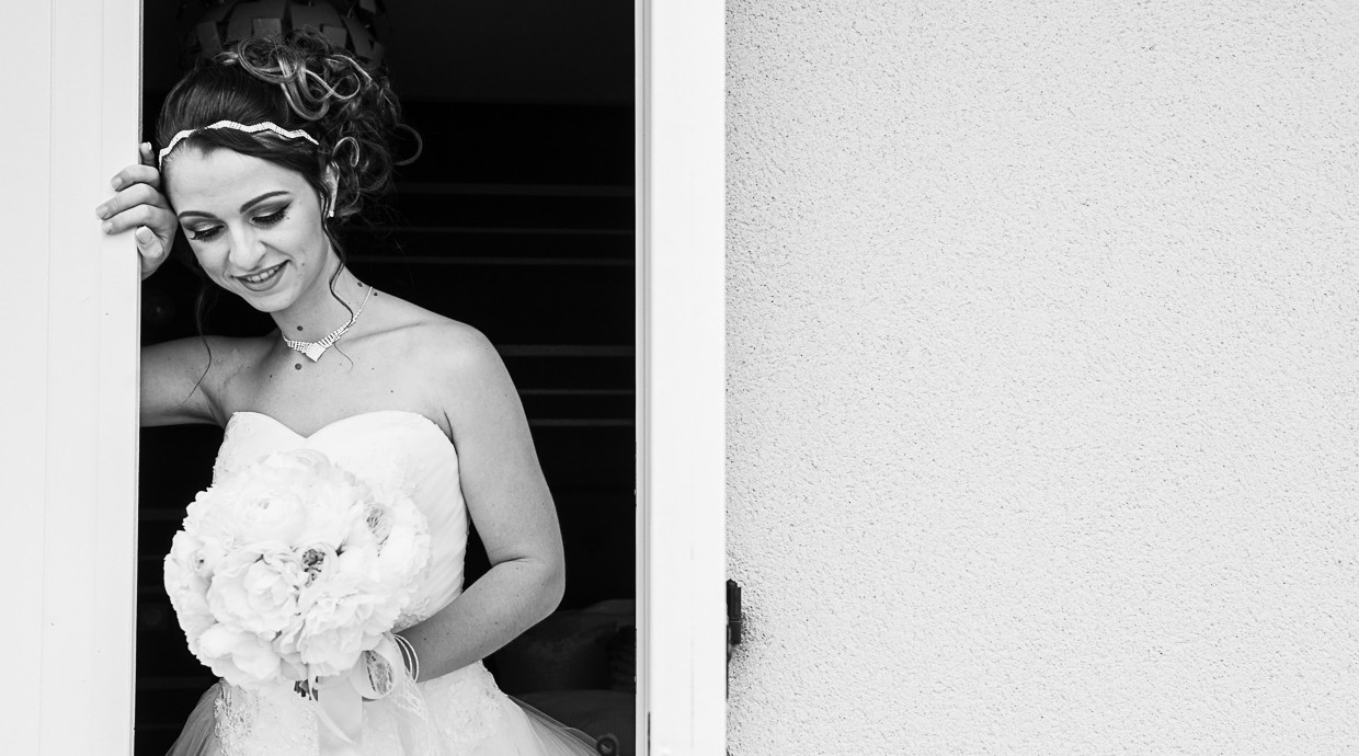 Noiva Charlène com a mão na parede e a com a outra mão a segurar o buque de flores