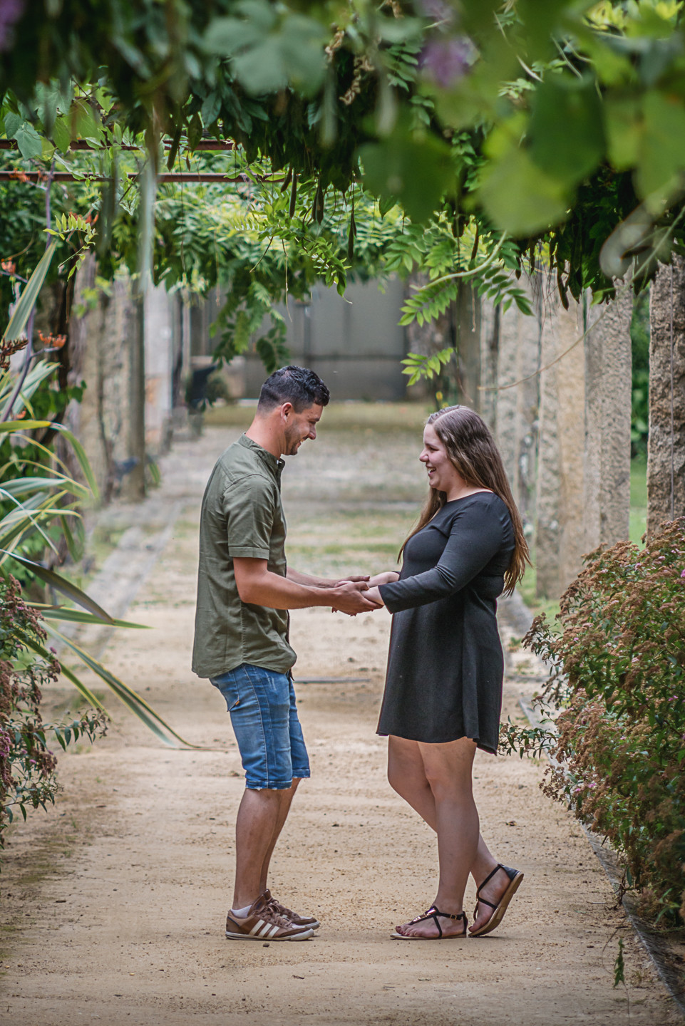 Casal de namorados a darem as m&atilde;os e a olhar um para o outro a rirem-se