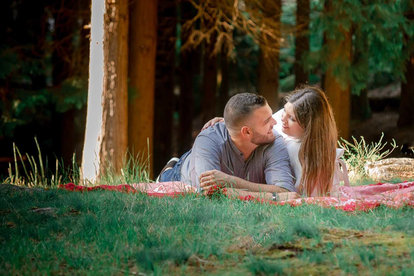 Carolina e André deitados na relva enquanto se olham apaixonadamente