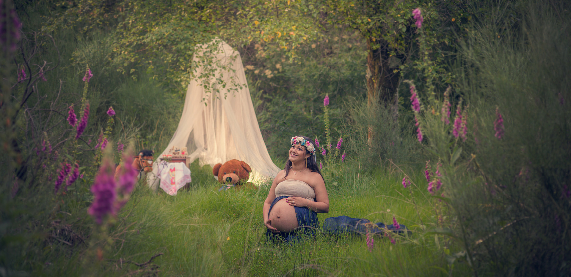 Grávida sentada na relva com um vestido azul