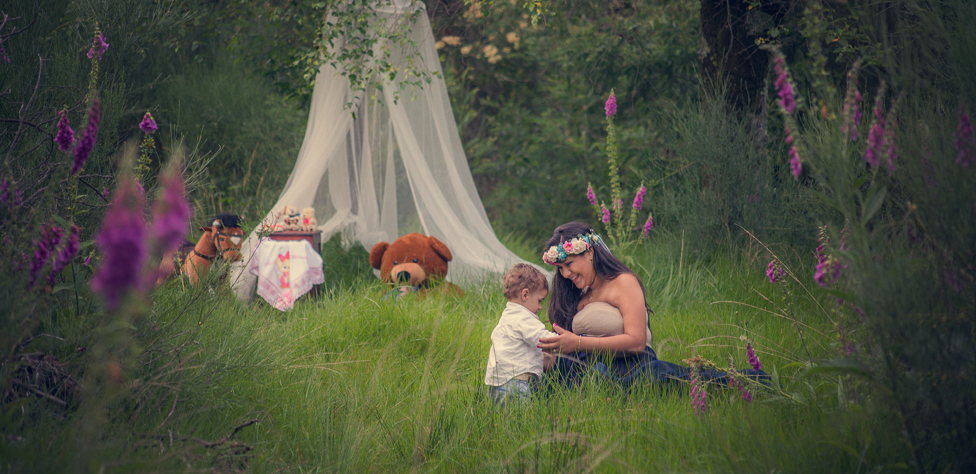 Grávida de vestido azul a brincar com o seu filho