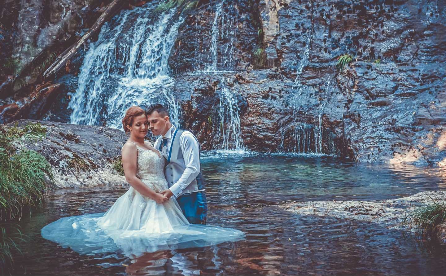 Noivos dentro do lago encostando a cabeça