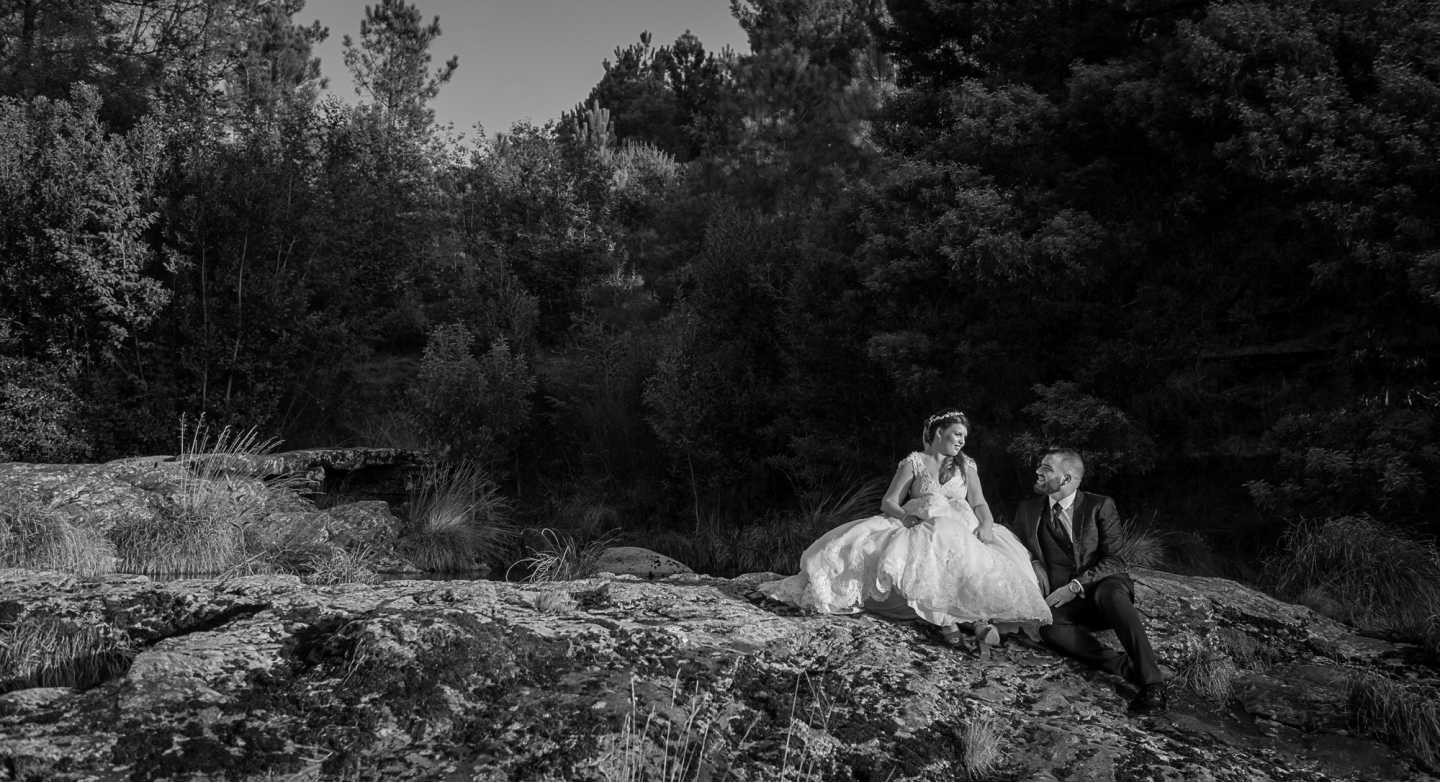 Noivos sentados nas rochas