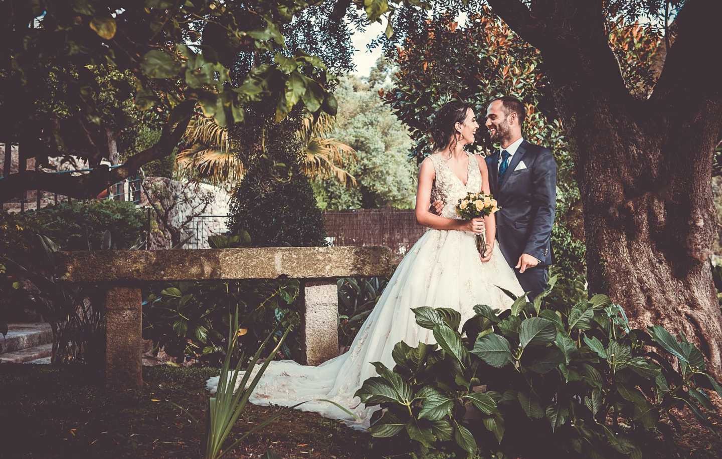 Noivos a olharem um para o outro a beira de um banco de jardim