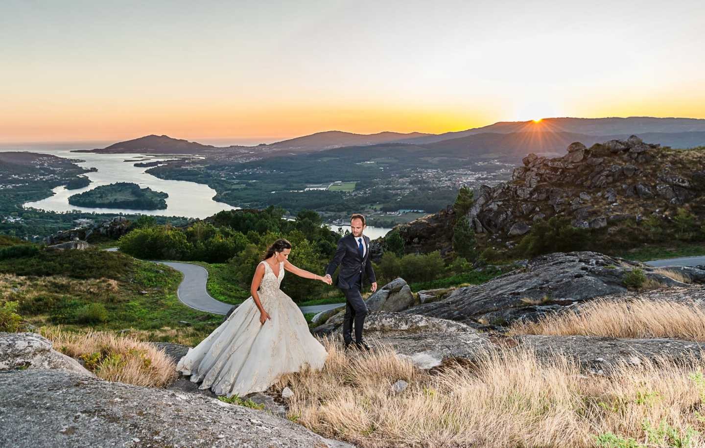 Noivos de mãos dadas a andarem pelas a montanhas