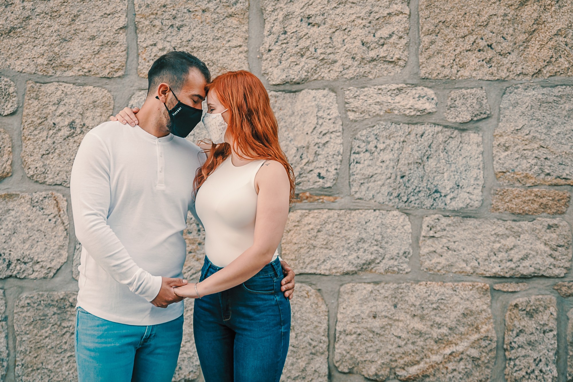 Casal de máscara enquanto dão as mãos