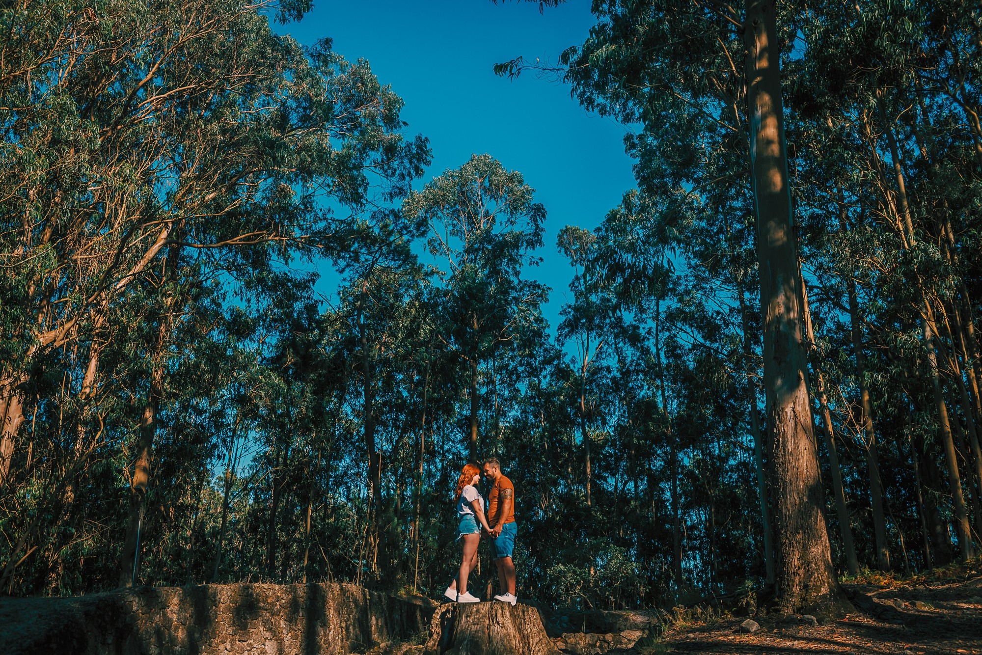 Casal em cima de uma rocha de mãos dadas
