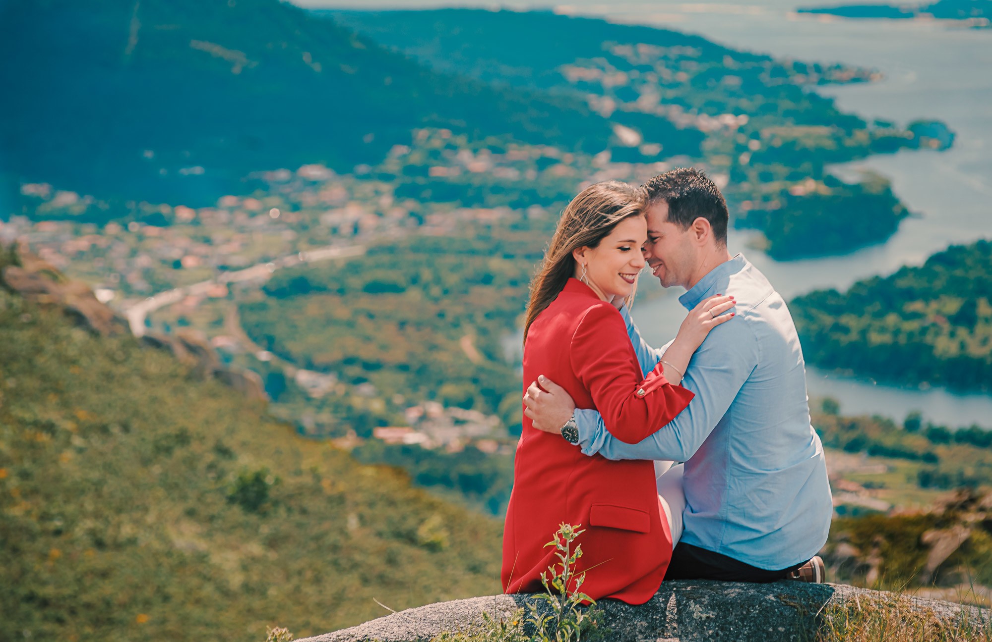 Casal sentados na montanha e a darem um abraço