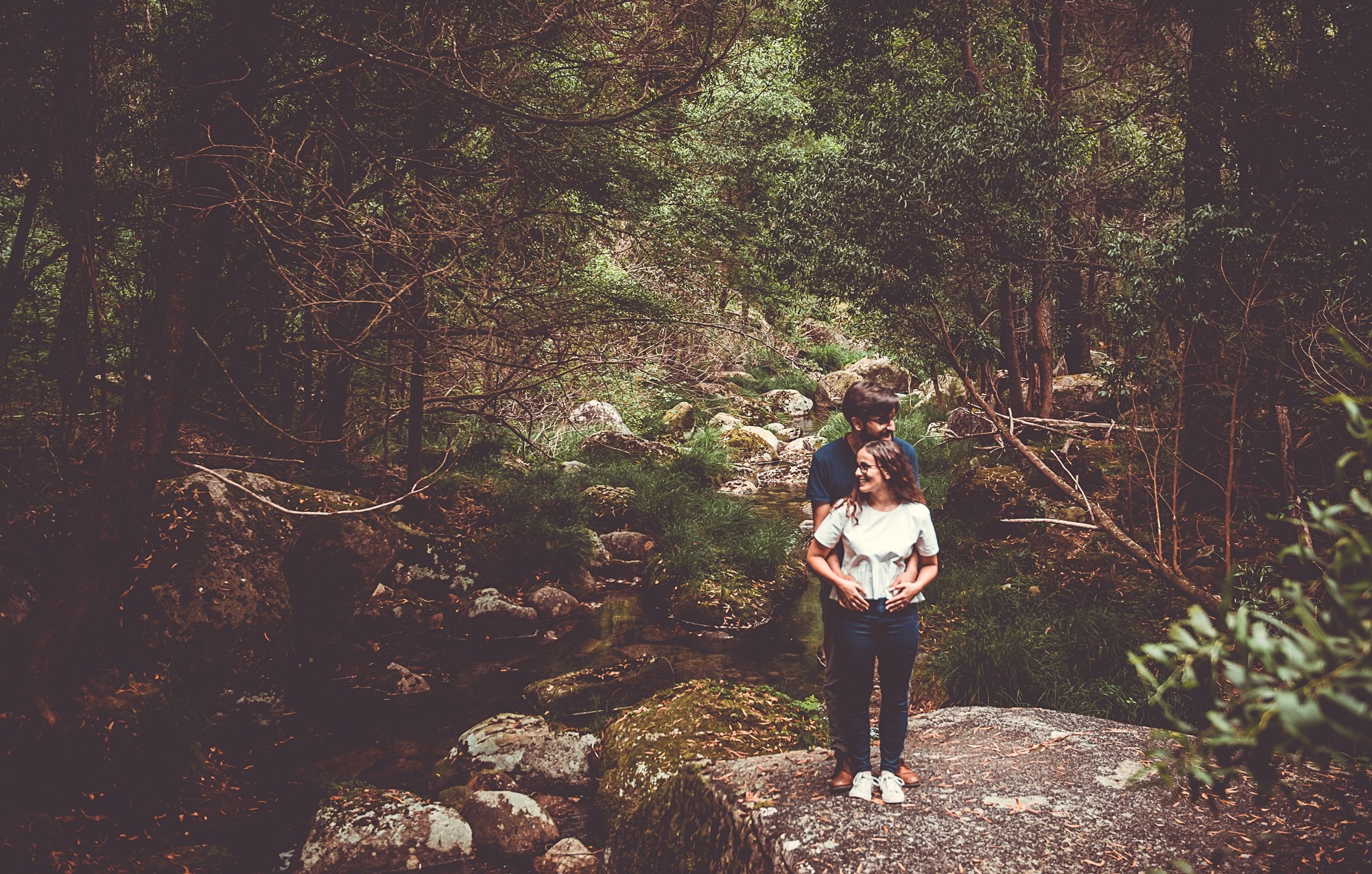 Filipe a abraçar por trás a Isabel em cima da rocha