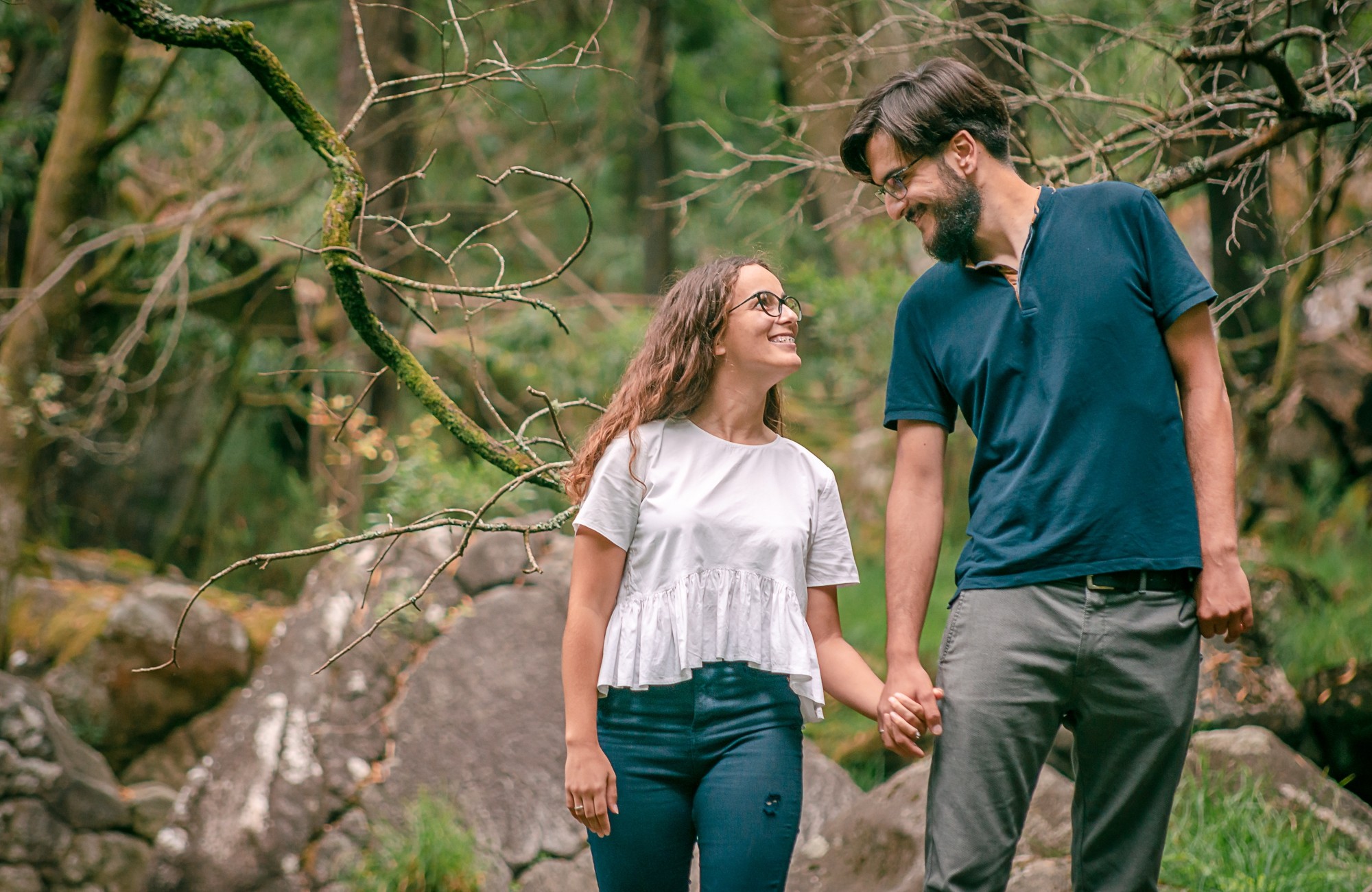 Casal a caminhar de mãos dadas e a olhar um para o outro