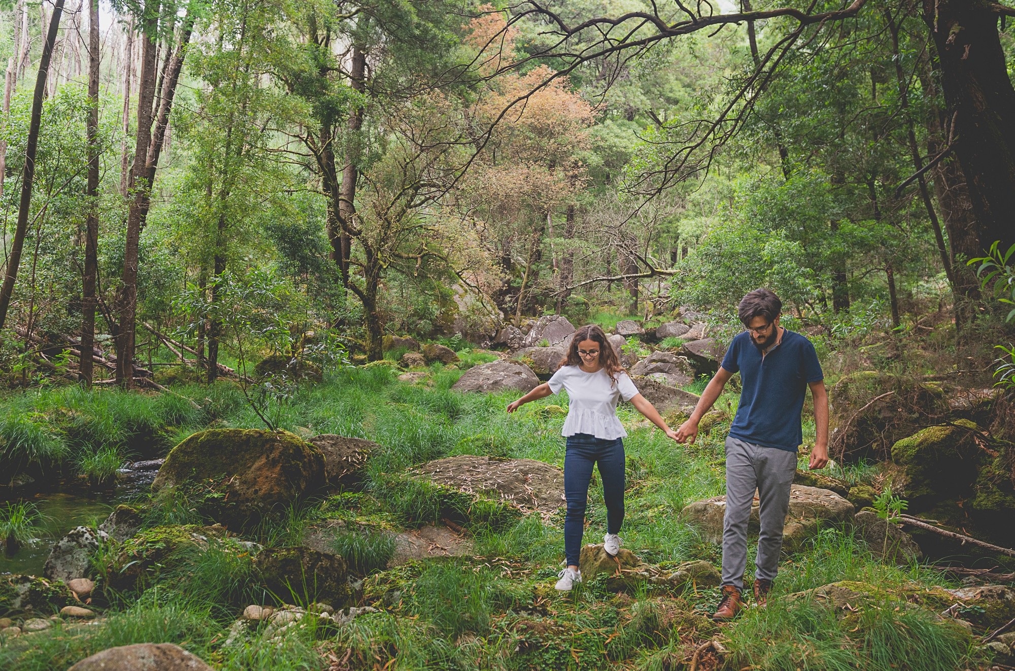 Casal a caminhar pelas as rochas de mãos dadas