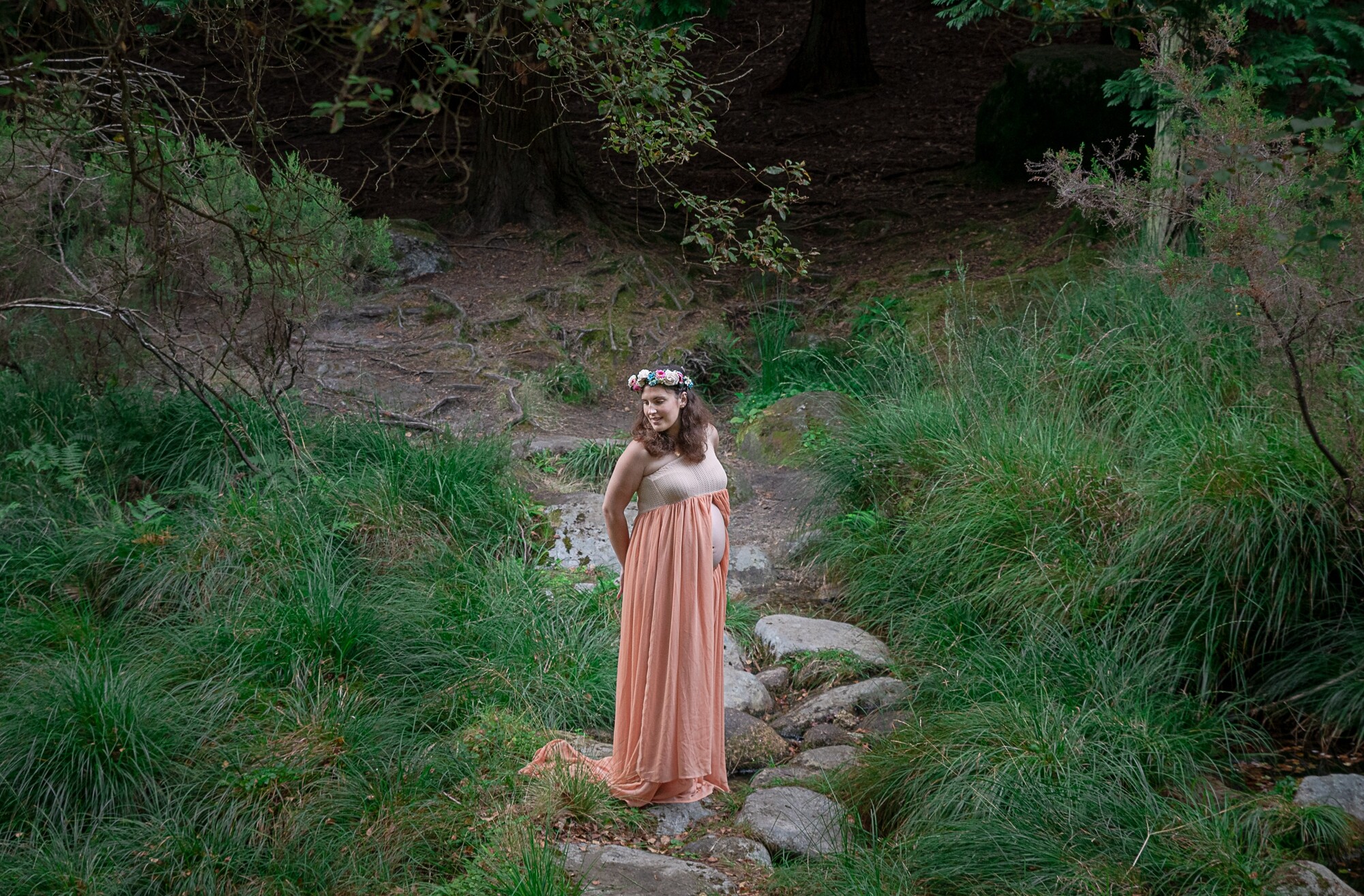 Pré-Mamã no meio do bosque a olhar para a relva