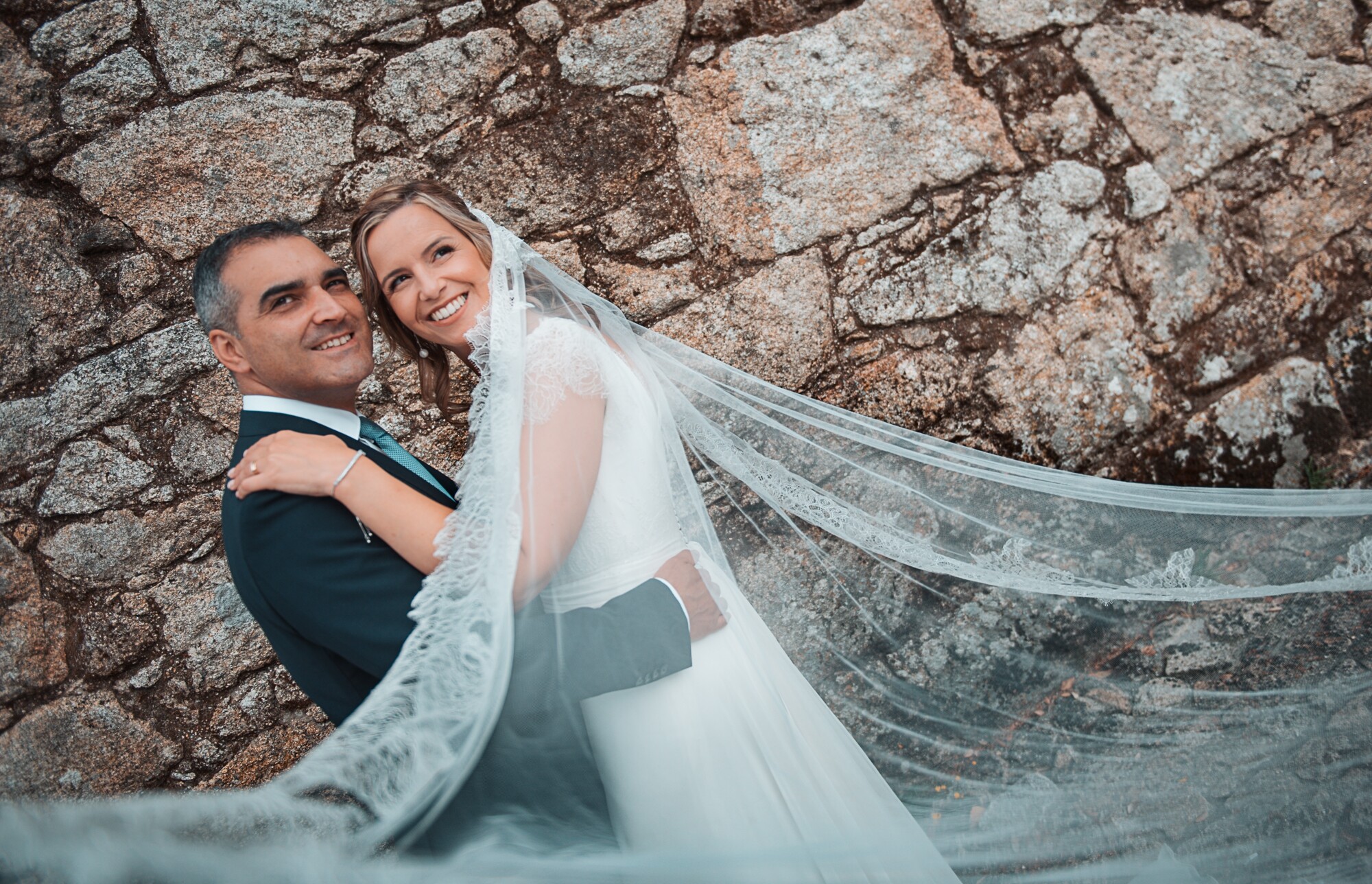 Casal a darem um abraço enquanto o véu aparece