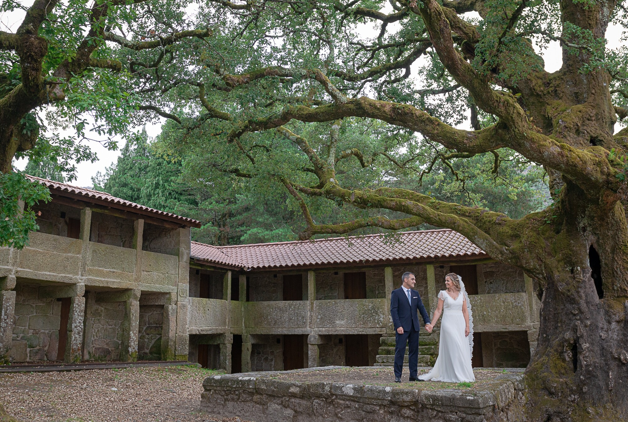Casal de mãos dadas a beira de uma casa de pedra