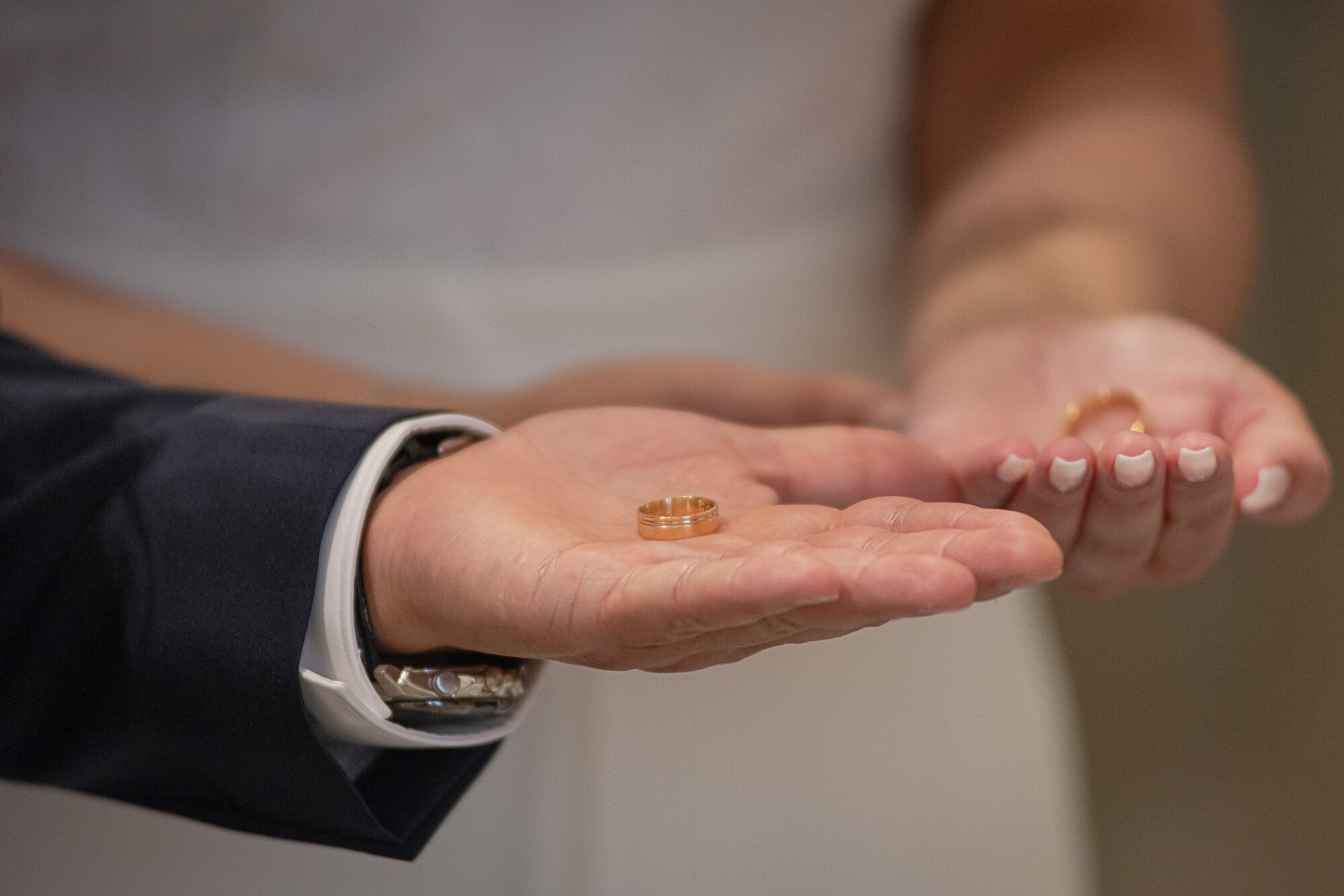 Mãos dos noivos com as alianças