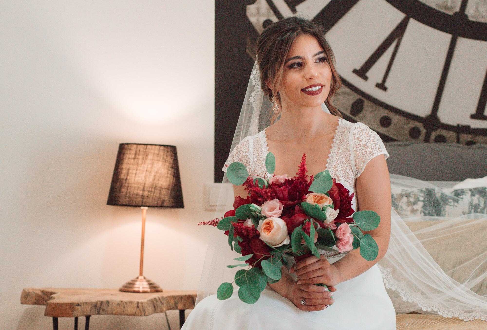 Noiva a olhar para o lado enquanto segura o buque de flores