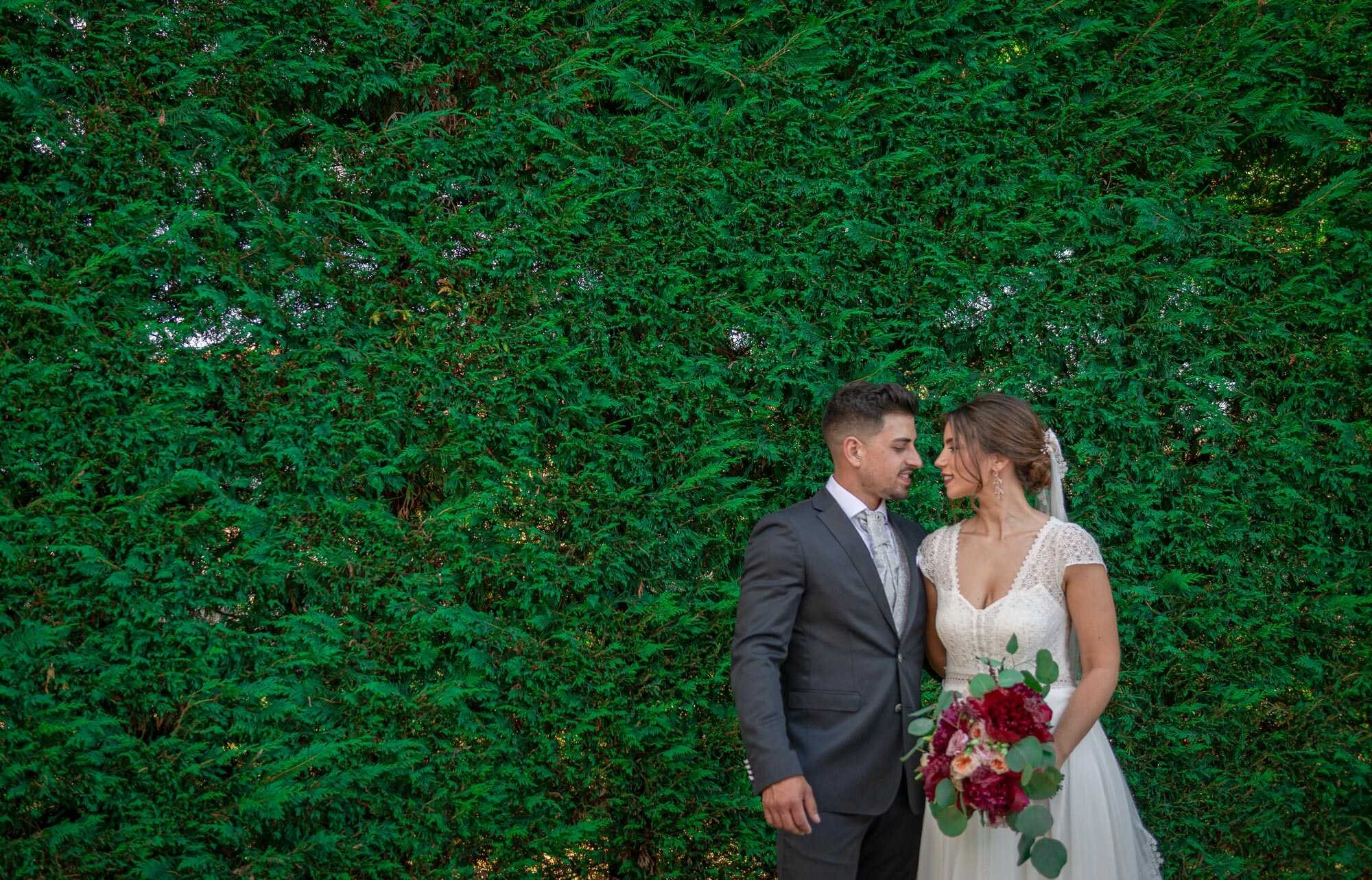 Casal a olharem um para o outro apaixonadamente a beira dos arbustros