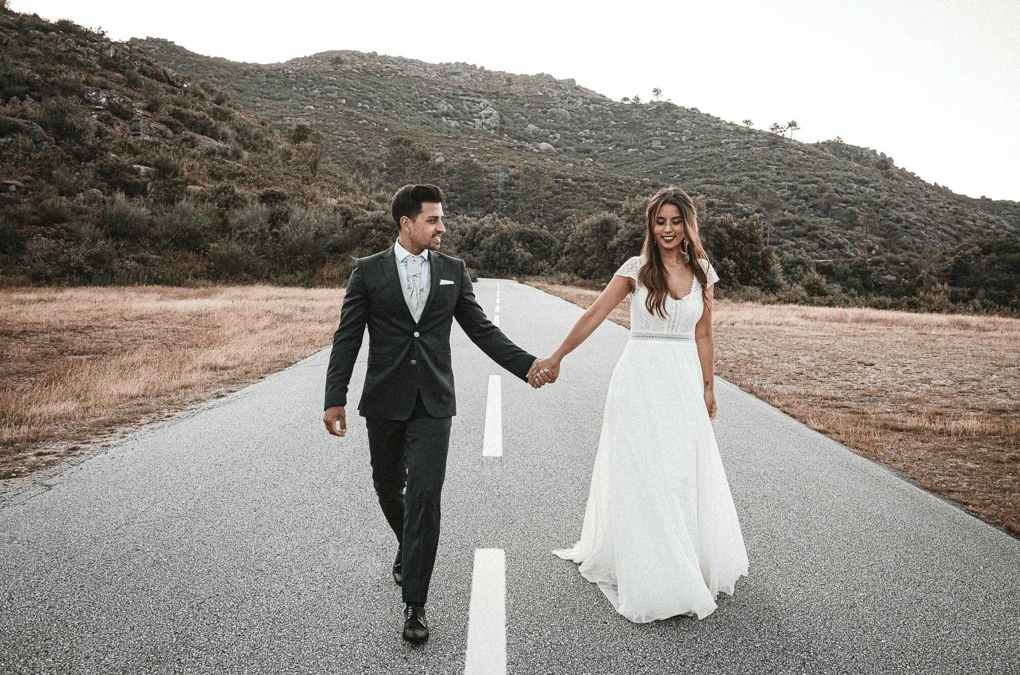 Casal a andar na estrada de mãos dadas