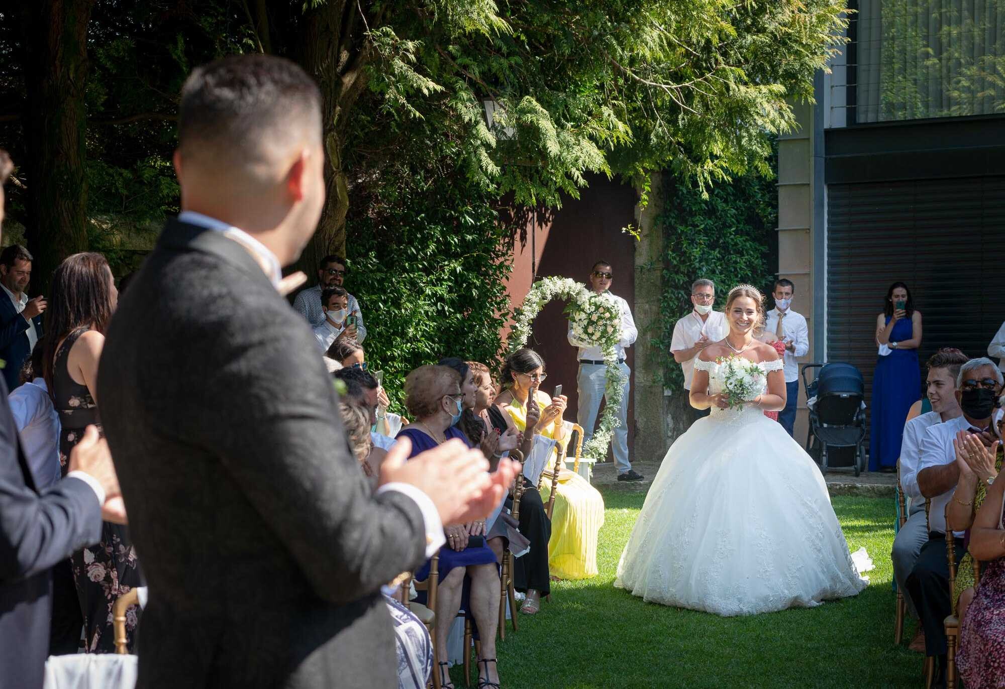 Noiva a caminhar até ao altar enquanto o noivo fica a olhar para ela