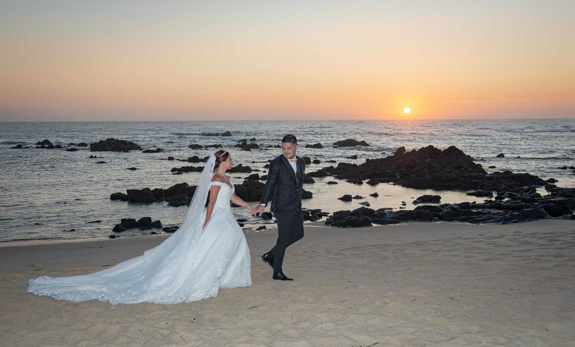 Casal a correr de mãos dadas na praia