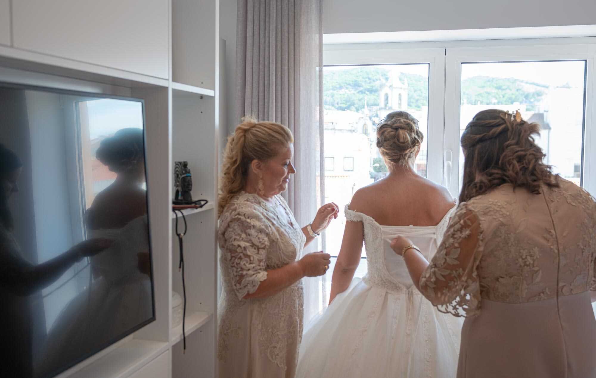 Mãe da Noiva e Madrinha a ajudarem com o vestido