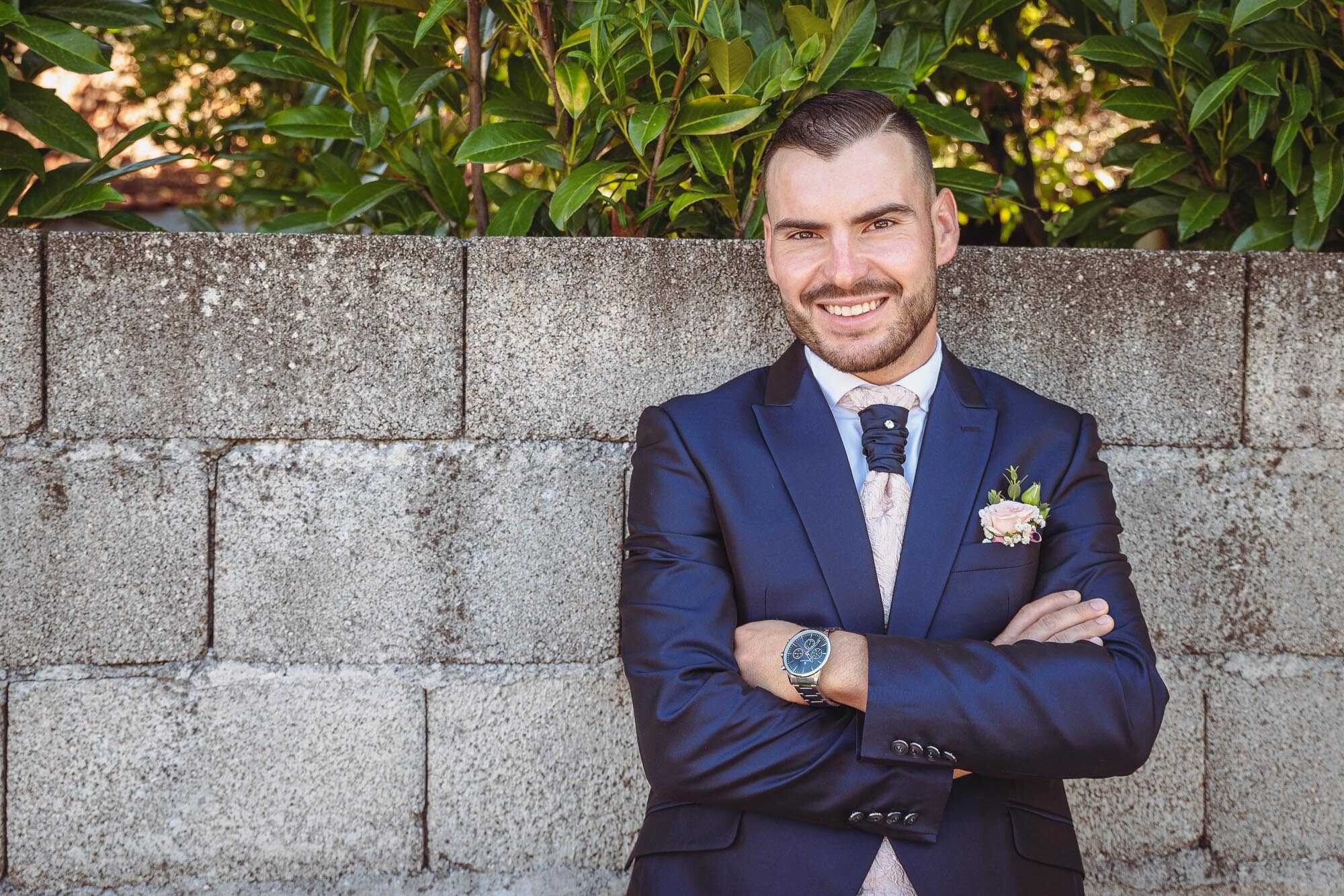 Noivo de braços cruzados e encostado na parede